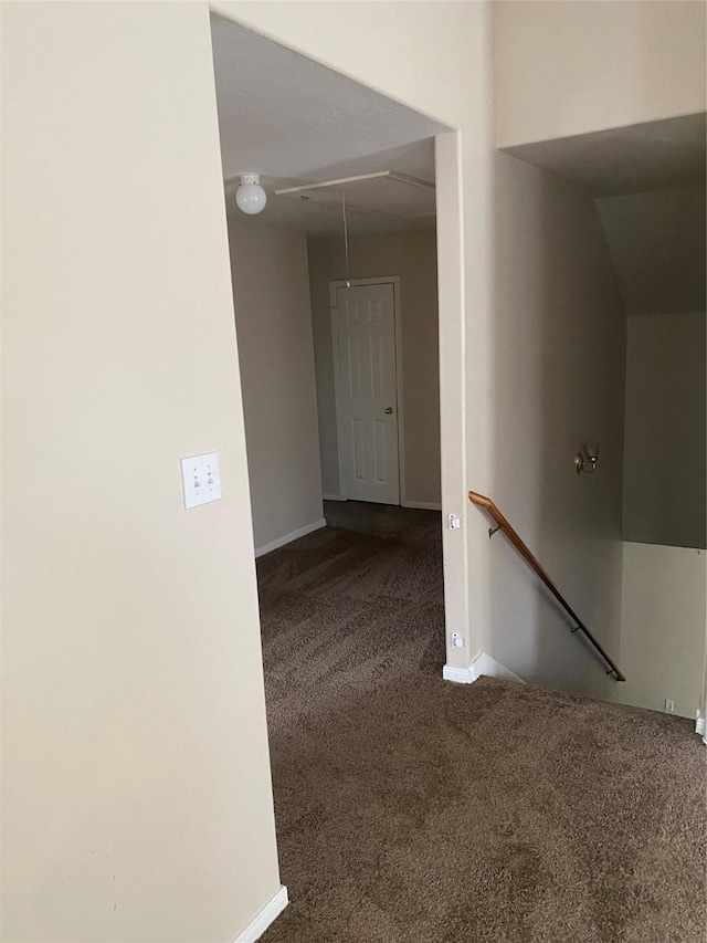 corridor featuring carpet and lofted ceiling