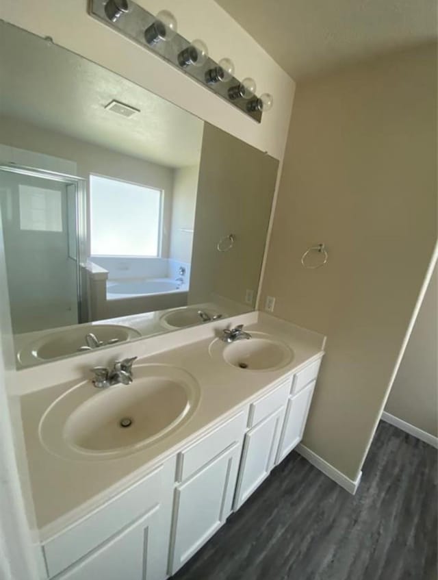 bathroom featuring independent shower and bath, vanity, and wood-type flooring