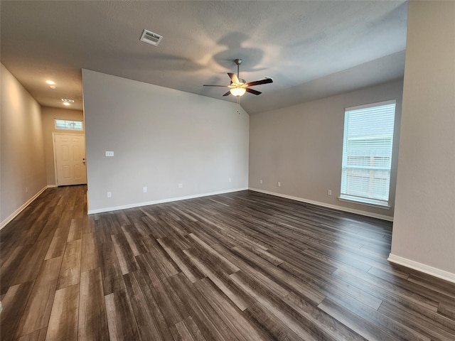 empty room with a textured ceiling, ceiling fan, and dark hardwood / wood-style floors