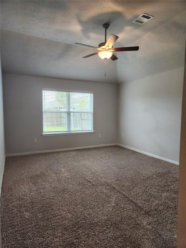 unfurnished room featuring carpet flooring, a textured ceiling, and vaulted ceiling