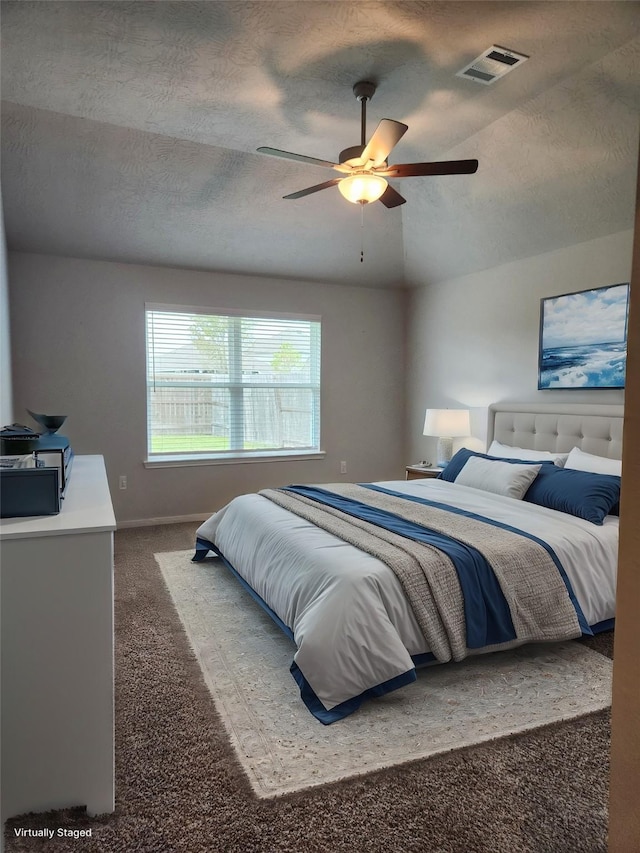 carpeted bedroom featuring ceiling fan, lofted ceiling, and a textured ceiling