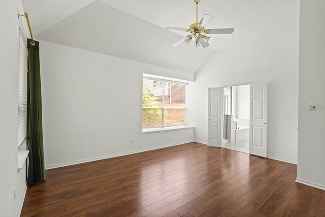 interior space featuring dark hardwood / wood-style flooring, ceiling fan, lofted ceiling, and connected bathroom