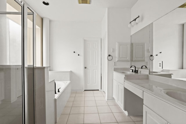 bathroom featuring tiled bath, tile patterned flooring, and vanity