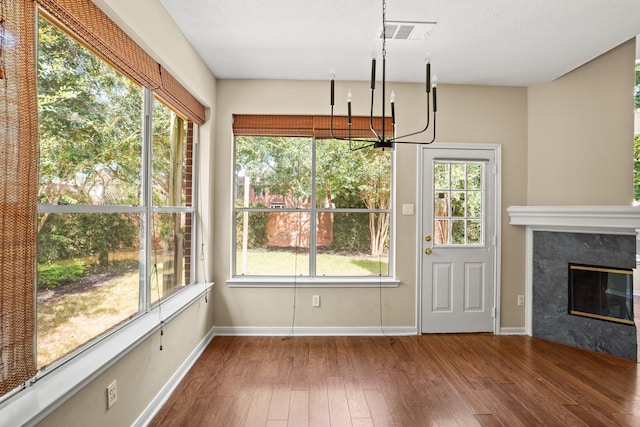 unfurnished dining area with hardwood / wood-style floors and a high end fireplace