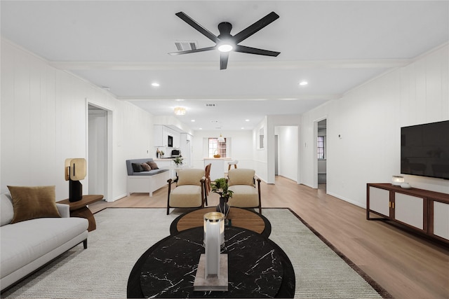 living room featuring plenty of natural light, ceiling fan, and light hardwood / wood-style flooring