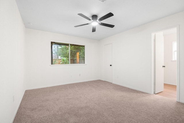 spare room with light carpet and ceiling fan