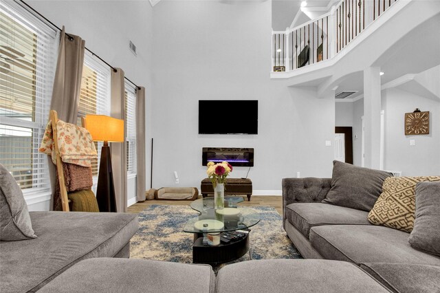 living room featuring wood-type flooring and a towering ceiling