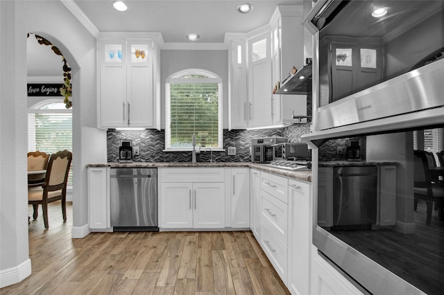 kitchen with white cabinets, light hardwood / wood-style flooring, plenty of natural light, and dishwasher