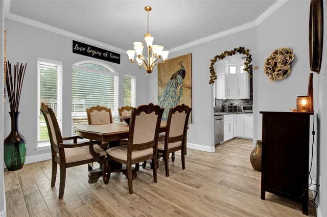 dining space featuring light hardwood / wood-style floors, ornamental molding, and an inviting chandelier