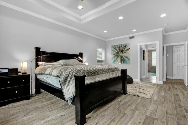 bedroom with ensuite bathroom, crown molding, and light hardwood / wood-style floors