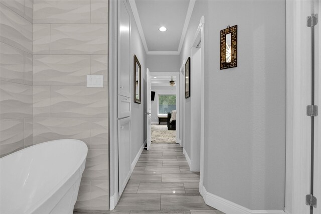 hallway with tile walls and crown molding