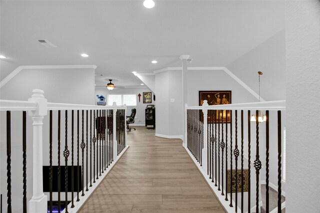 hallway with light hardwood / wood-style floors and crown molding