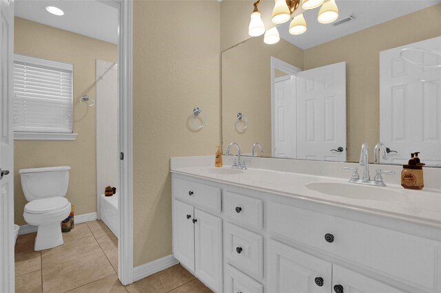 bathroom with tile patterned flooring, vanity, and toilet