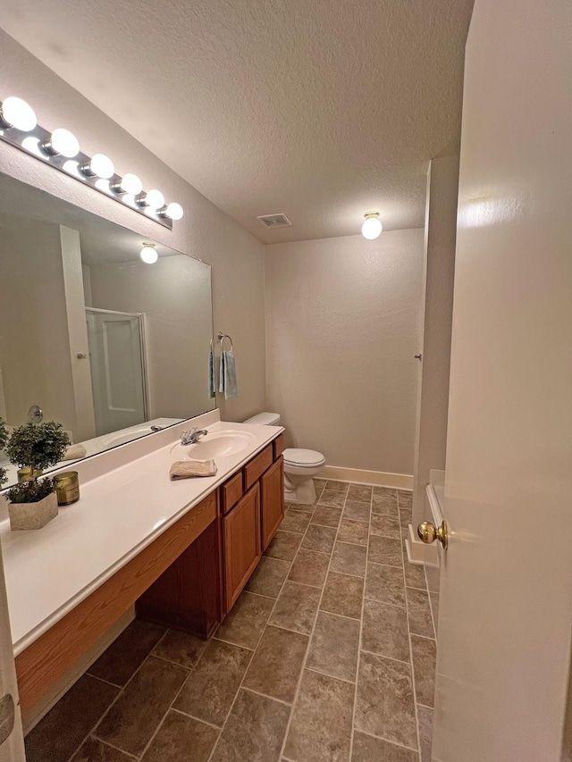 bathroom with walk in shower, tile patterned flooring, a textured ceiling, toilet, and vanity