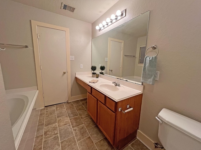 bathroom featuring a bathtub, vanity, a textured ceiling, and toilet