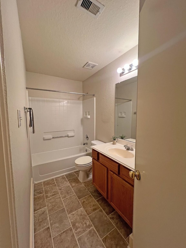 full bathroom with vanity, tub / shower combination, toilet, and a textured ceiling