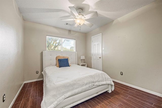 bedroom featuring ceiling fan, dark hardwood / wood-style flooring, and a textured ceiling