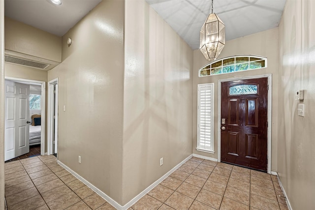 tiled foyer featuring a chandelier