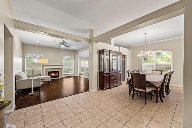 dining room featuring ceiling fan with notable chandelier, crown molding, a wealth of natural light, and light hardwood / wood-style flooring