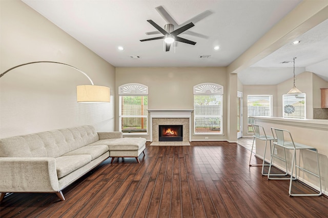 living room with a tile fireplace, dark hardwood / wood-style floors, ceiling fan, and lofted ceiling