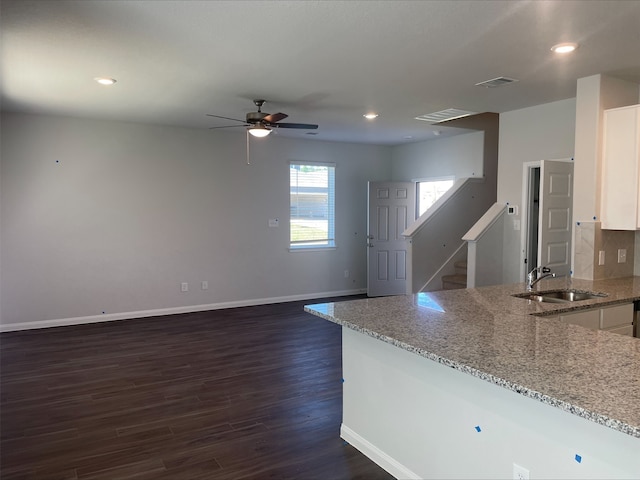 kitchen featuring light stone countertops, dark hardwood / wood-style flooring, ceiling fan, sink, and white cabinets