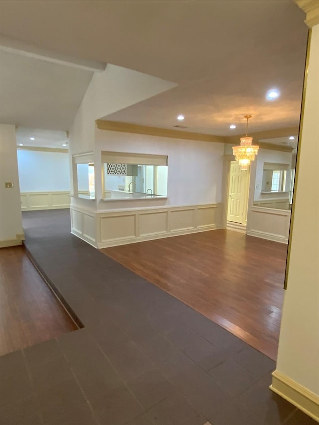 empty room featuring dark hardwood / wood-style flooring, lofted ceiling, and an inviting chandelier