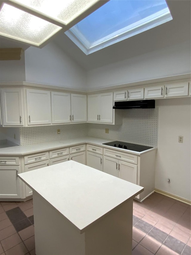 kitchen with black electric stovetop, white cabinets, light tile patterned floors, and tasteful backsplash