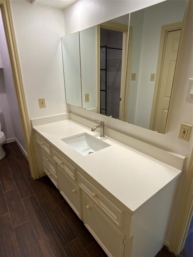 bathroom with hardwood / wood-style floors, vanity, and toilet