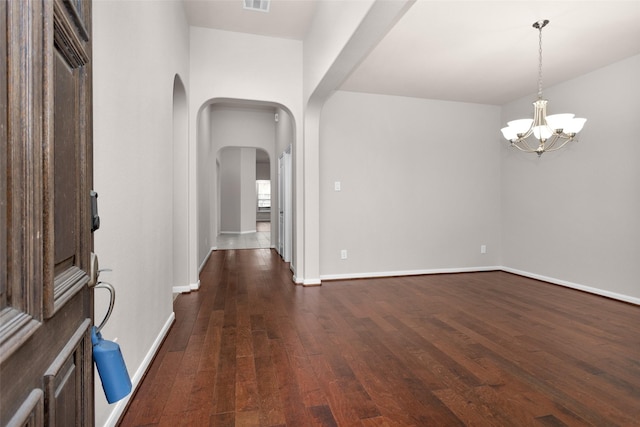 interior space featuring an inviting chandelier and dark wood-type flooring