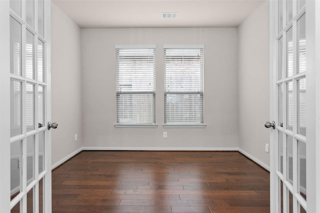 empty room featuring dark hardwood / wood-style flooring and french doors