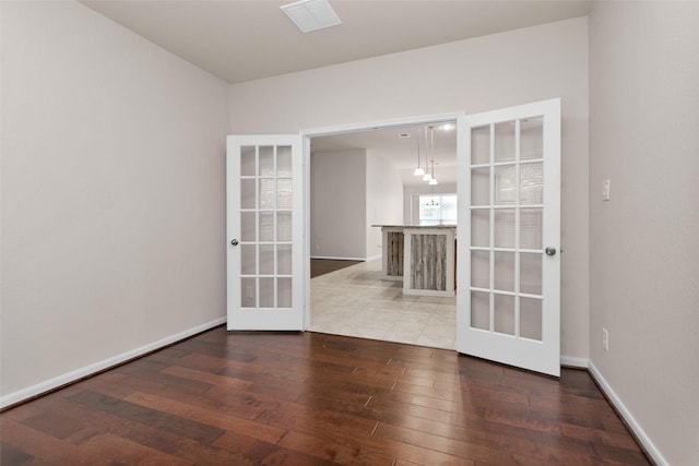 empty room featuring french doors and hardwood / wood-style floors