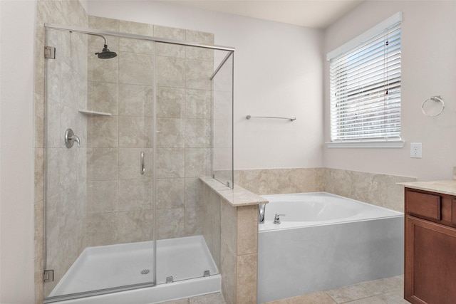 bathroom featuring tile patterned floors, vanity, and shower with separate bathtub