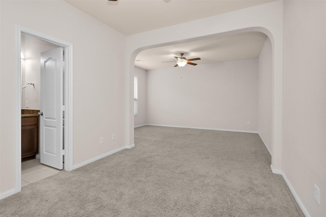 carpeted spare room featuring ceiling fan