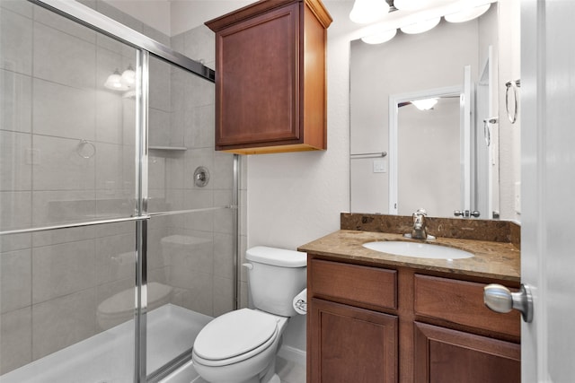 bathroom featuring toilet, vanity, and walk in shower