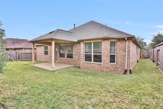 rear view of house featuring a patio area and a yard