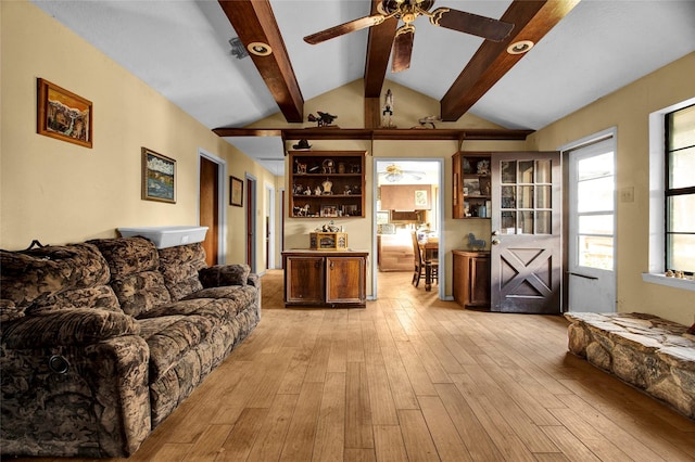 living room with ceiling fan, lofted ceiling with beams, and light wood-type flooring