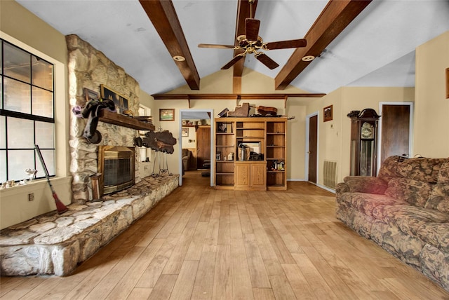 living room with a fireplace, lofted ceiling with beams, light hardwood / wood-style floors, and ceiling fan