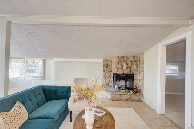 living room with a textured ceiling, lofted ceiling, light tile patterned floors, and a fireplace