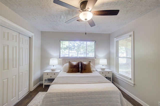 bedroom with dark hardwood / wood-style flooring, ceiling fan, a closet, and a textured ceiling