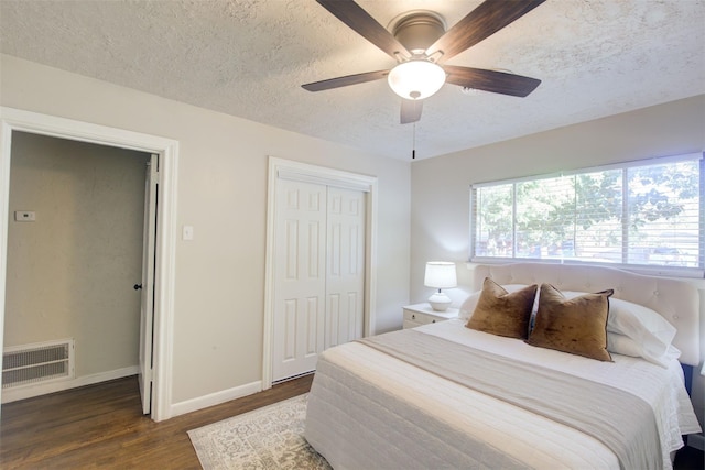 bedroom featuring a closet, ceiling fan, dark hardwood / wood-style flooring, and a textured ceiling