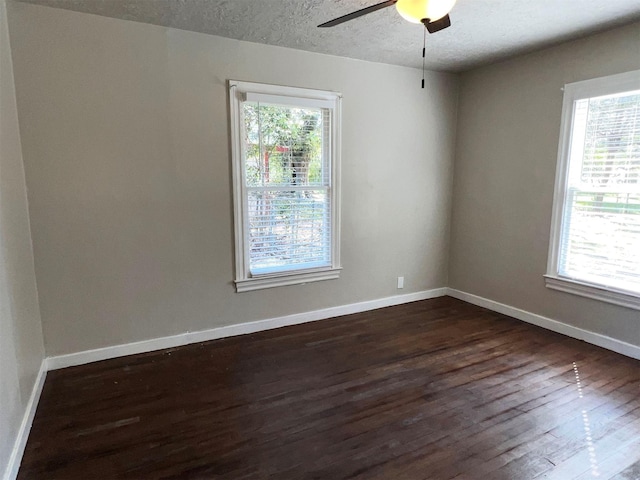 unfurnished room with plenty of natural light, dark hardwood / wood-style floors, a textured ceiling, and ceiling fan