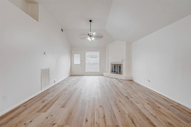 unfurnished living room featuring visible vents, lofted ceiling, ceiling fan, light wood-style floors, and a fireplace