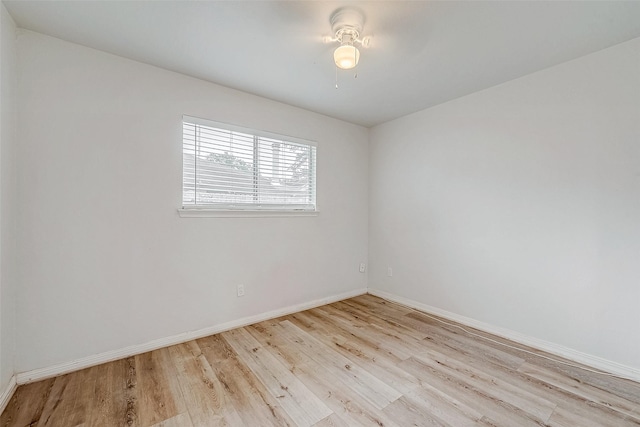 empty room with baseboards and light wood-style floors