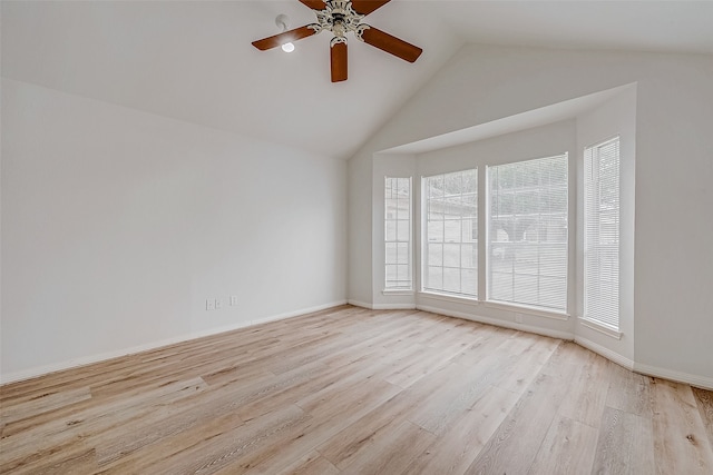 empty room with light wood finished floors, ceiling fan, baseboards, and vaulted ceiling