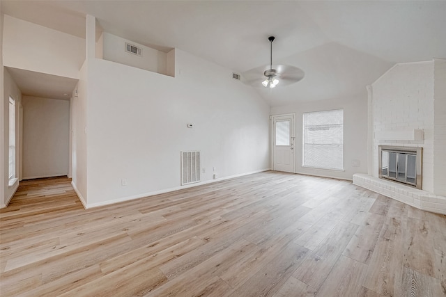 unfurnished living room with light wood-style floors, visible vents, a fireplace, and a ceiling fan