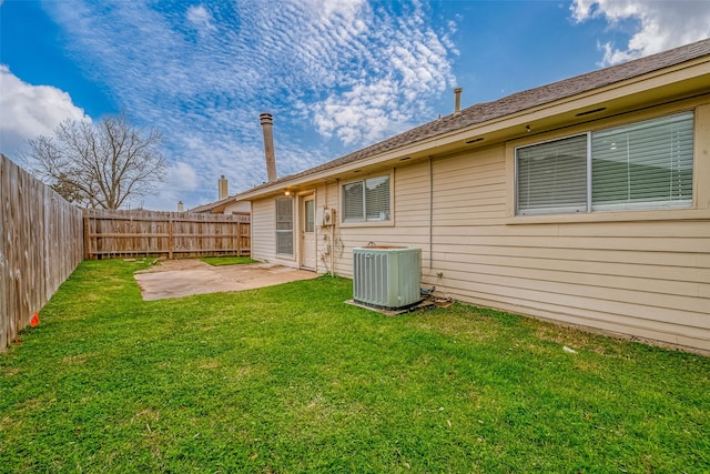 back of property with central AC, a patio, a fenced backyard, and a lawn