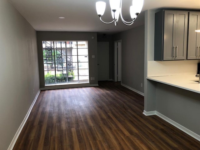 unfurnished dining area featuring dark hardwood / wood-style floors and a chandelier