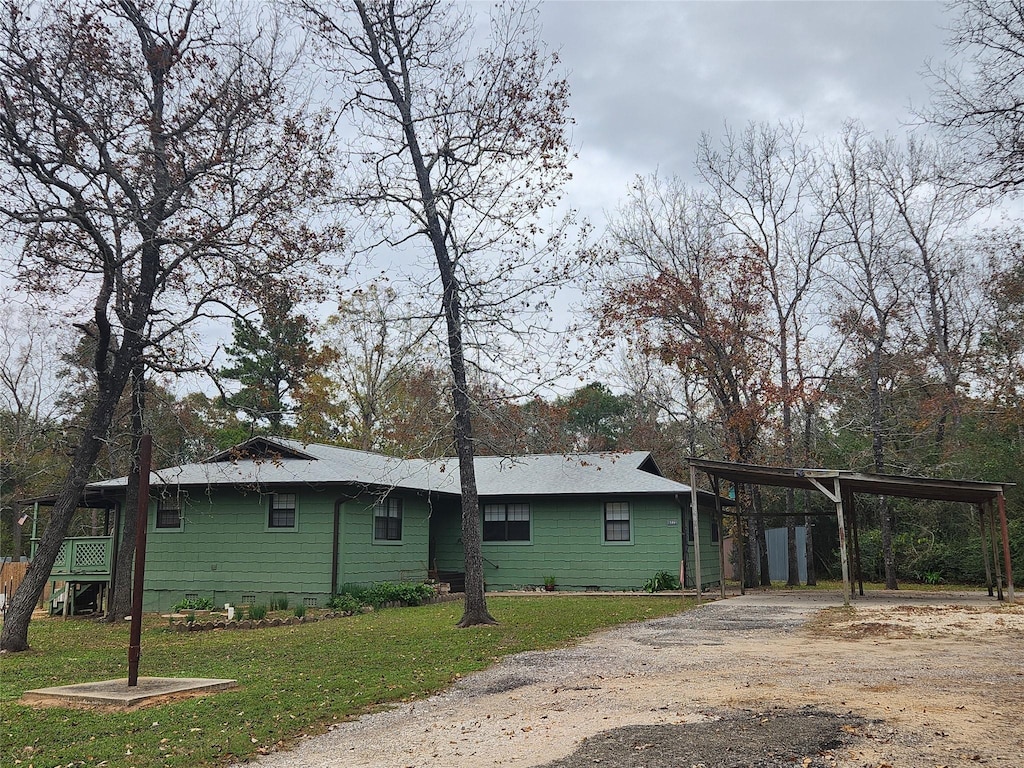 rear view of house with a carport and a lawn