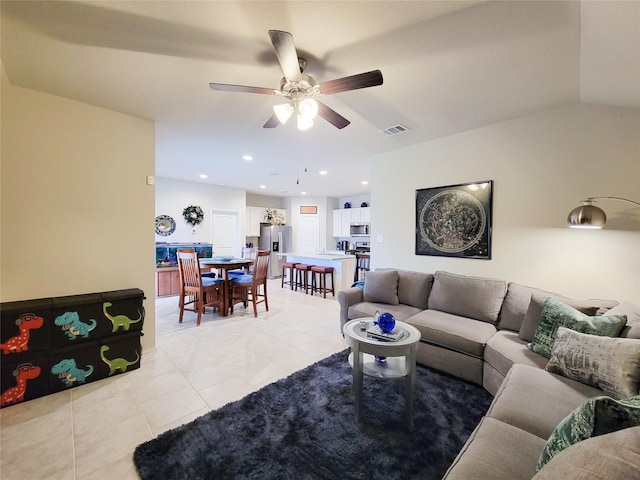 tiled living room with ceiling fan and vaulted ceiling