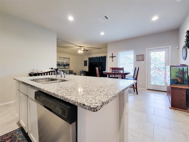 kitchen with ceiling fan, sink, dishwasher, white cabinetry, and an island with sink